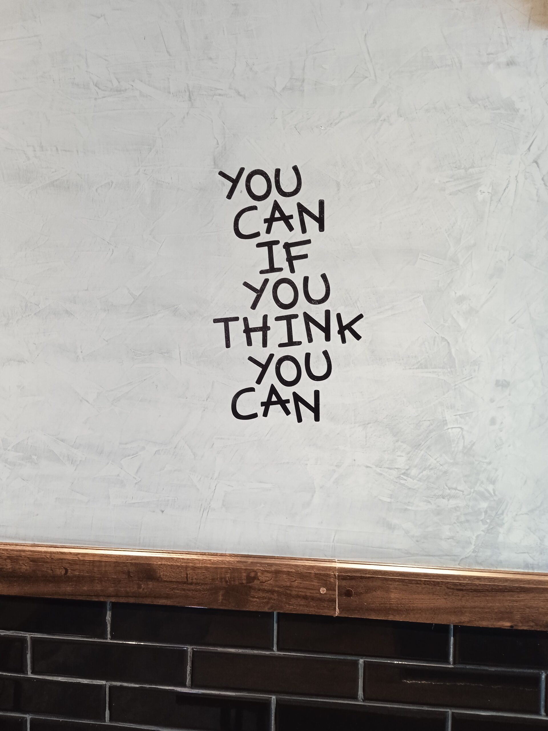Motivational quote on a textured wall in a modern urban interior setting.